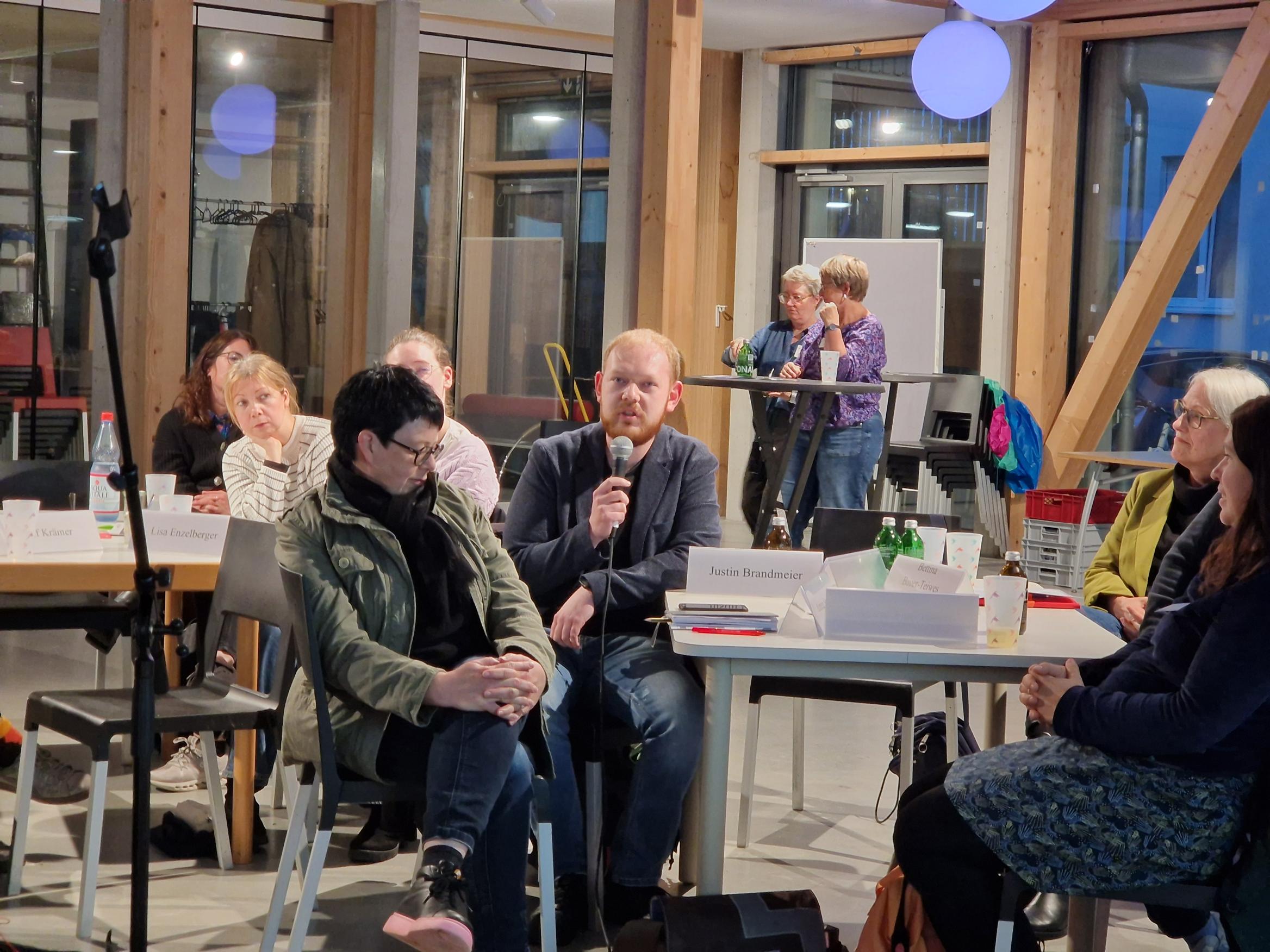 mehrere Menschen an Tischen diskutieren