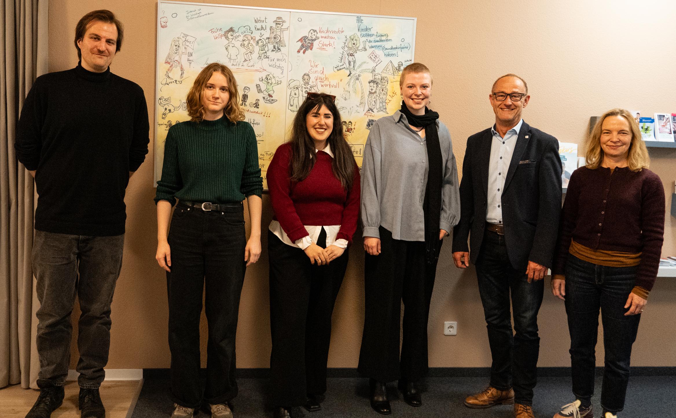 6 Personen vor einer beigen Wand