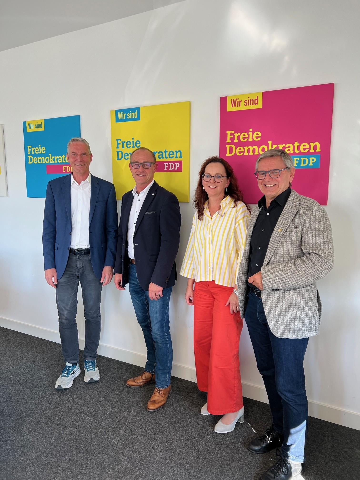 4 Personen vor einer Wand mit Plakaten