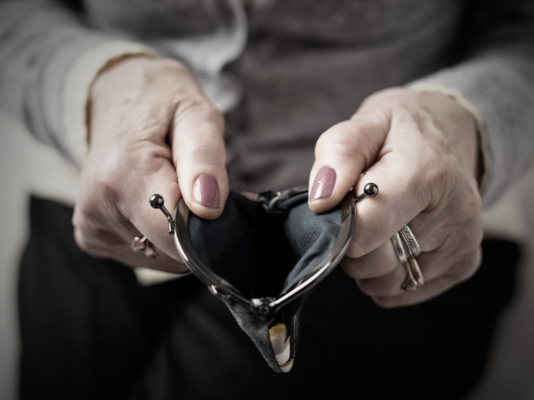 die Hände einer älteren Dame halten ein geöffnetes Portemonnaie