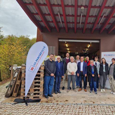 mehrere Personen vor einer Werkstatt