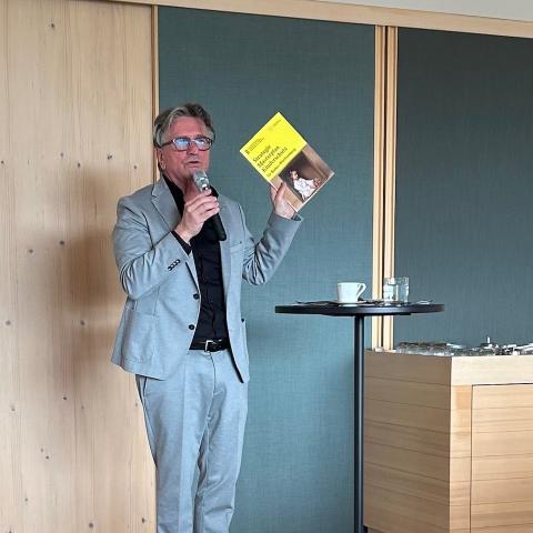 Mann mit einem gelben Heft in der Hand