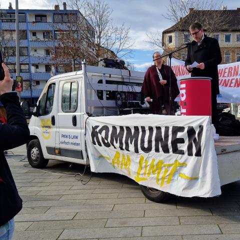 Alexander Manz steht auf der Ladefläche eines Autos am Rednerpult und spricht