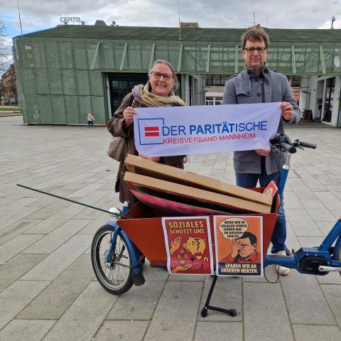 Die Co-Kreisvorsitzenden Frau Dr. Schöning-Kalender und Herr Gerber halten das Banner des Paritätischen Kreisverbands hoch.