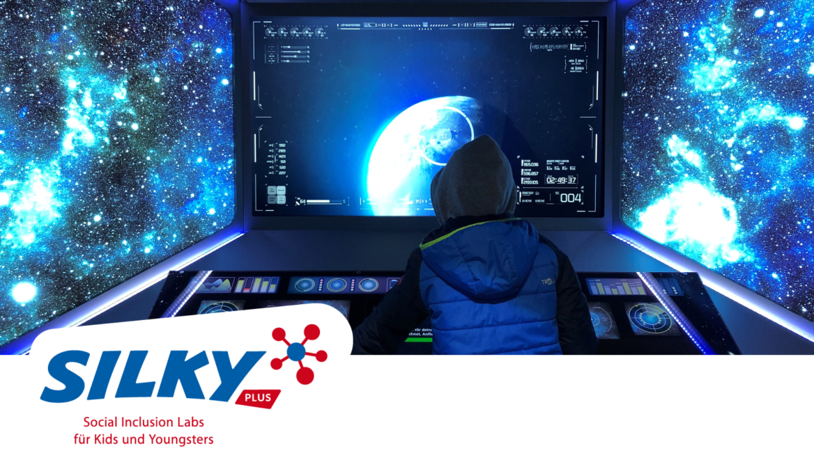 Junge mit blauer Jacke und Mütze steht vor Navigationspc und blickt ins Weltall