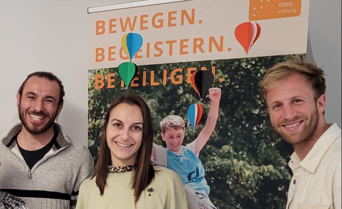 3 Mitarbeiter*innen der step Stiftung vor ihrem Roll-up