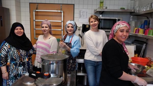 mehrere Frauen in einer Küche mit großen Töpfen