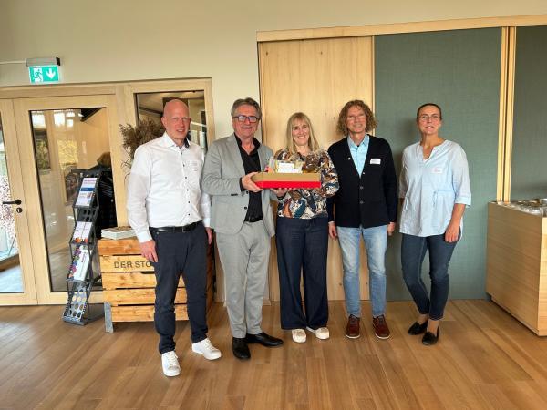 drei Männer und zwei Frauen mit Geschenkkarton