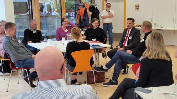 viele Menschen sitzen zusammen und diskutieren