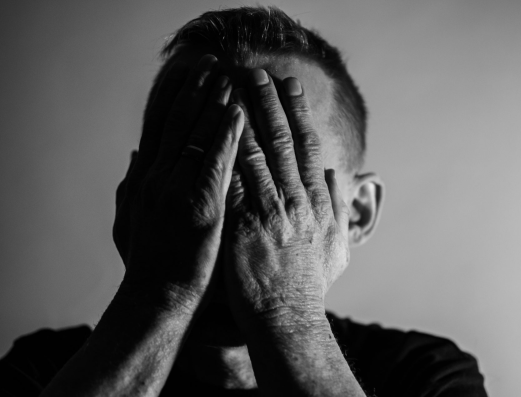 Mann hält sich beschämt die Hände vors Gesicht