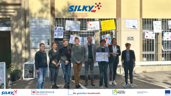 Männer und Frauen stehen vor Kinderplakaten