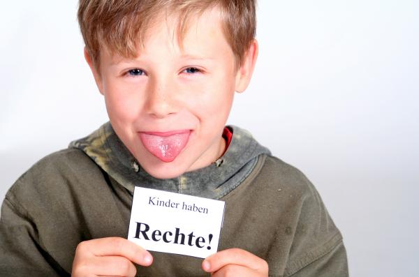 Junge mit Schild Kinder haben Rechte