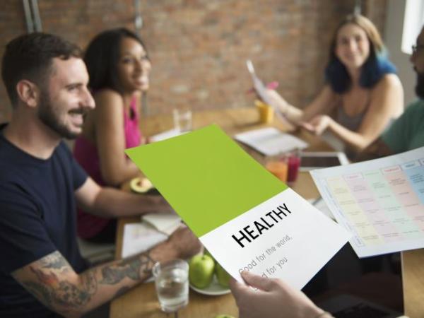 Männer und Frauen sitzen freudig am Tisch