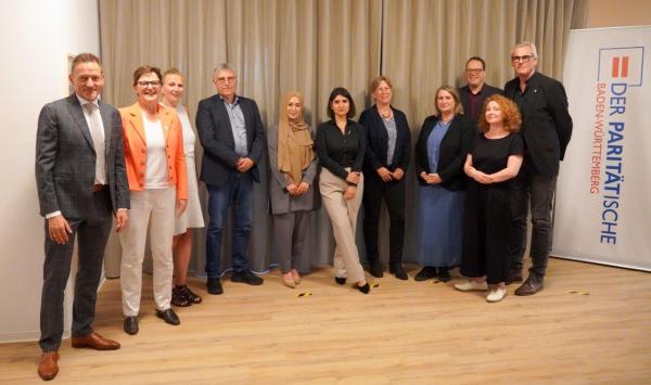 Frauen und Männer stehen im Halbkreis