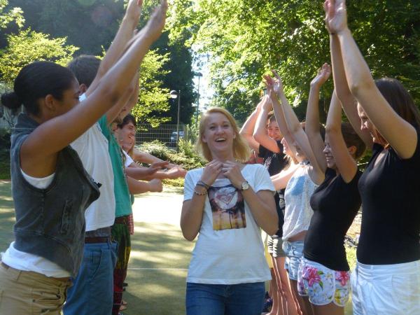 Junge Menschen heben die Arme