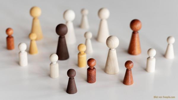 Verscheiden farbige Holzfiguren auf weißer Fläche