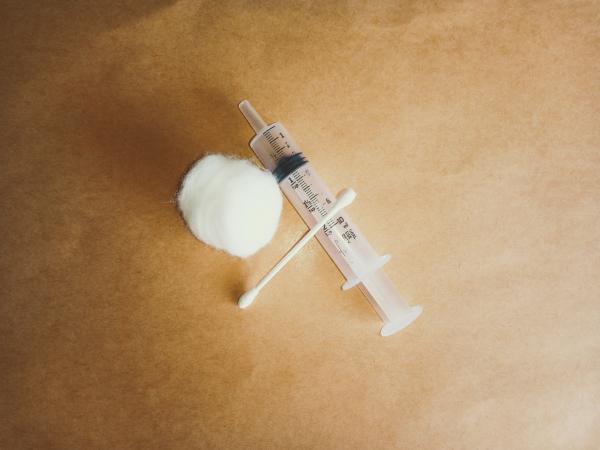 Spritze mit Wattestäbchen und Wattebausch