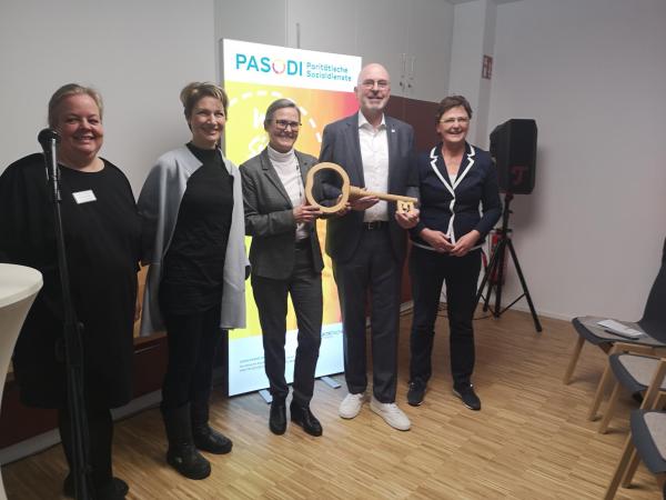 Eine Gruppe von Menschen mit einem übergroßen Schlüssel in den Händen