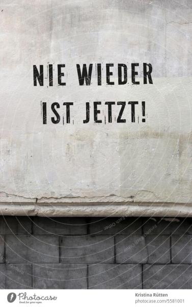 Weiße Wand mit schwarzer Beschriftung