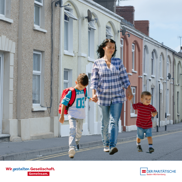 Junge Frau mit zwei kleinen Kindern überquert eine Straße