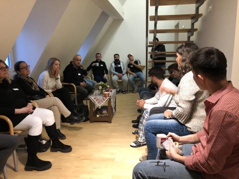 Verschiedene Personen, die im Stuhlkreis diskutieren 